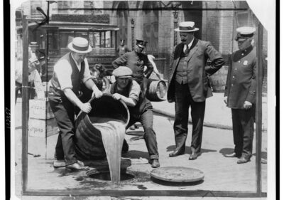 1921 police raid pours confiscated liquor into sewer during alcohol Prohibition